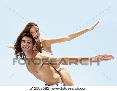 Stock Image - Young attractive couple enjoying summer holiday on beach. Fotosearch