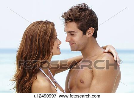 Young attractive couple enjoying summer holiday on beach View Large Photo Image Stock Photo - Young attractive couple enjoying summer holiday on beach. Fotosearch