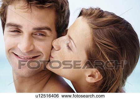 Stock Photograph - Young attractive couple enjoying summer holiday on beach. Fotosearch