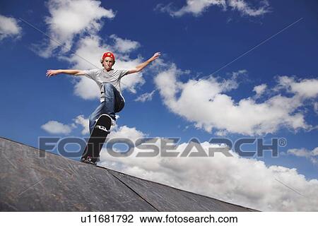Stock Image - Young man on skateboard jumping. Fotosearch