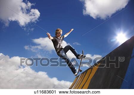 Young man on skateboard jumping View Large Photo Image Stock Image - Young man on skateboard jumping. Fotosearch