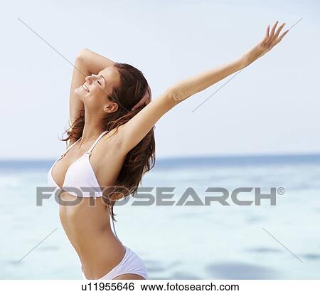 Young woman in bikini, arms outstretched View Large Photo Image Stock Photograph - Young woman in bikini, arms outstretched. Fotosearch