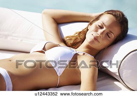 Young woman in bikini resting at swimming pool View Large Photo Image Stock Image - Young woman in bikini resting at swimming pool. Fotosearch