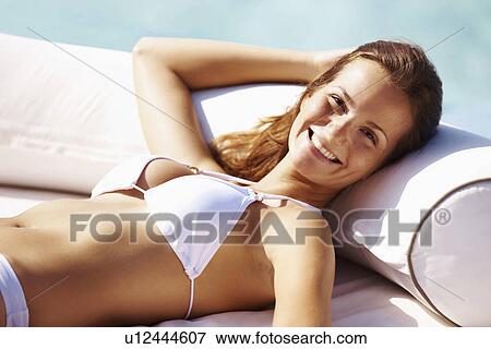 Young woman in bikini resting at swimming pool View Large Photo Image Stock Photo - Young woman in bikini resting at swimming pool. Fotosearch