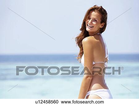 Young woman in bikini standing on jetty View Large Photo Image Stock Image - Young woman in bikini standing on jetty. Fotosearch