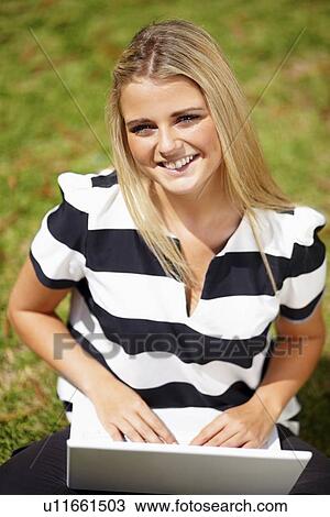 Young woman in park using laptop View Large Photo Image Stock Image - Young woman in park using laptop. Fotosearch