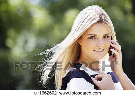 Young woman in park using mobile phone View Large Photo Image Stock Image - Young woman in park using mobile phone. Fotosearch