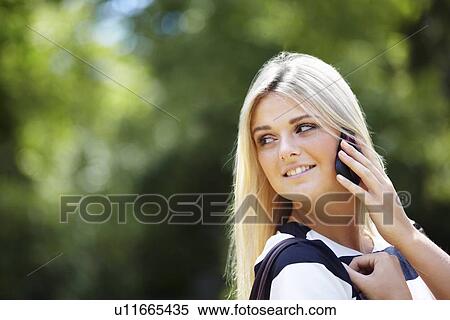 Young woman in park using mobile phone View Large Photo Image Stock Photography - Young woman in park using mobile phone. Fotosearch