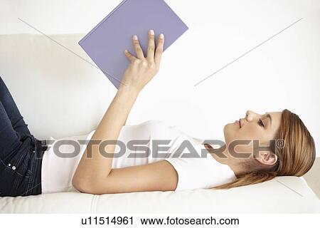 Young woman lying on bed and reading View Large Photo Image Stock Image - Young woman lying on bed and reading. Fotosearch