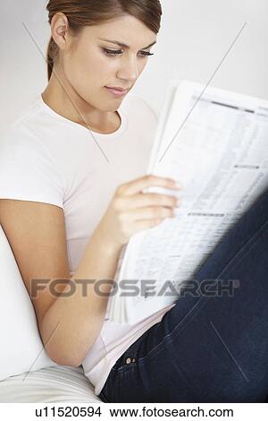 Picture - Young woman reading newspaper. Fotosearch
