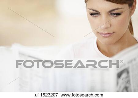 Young woman reading newspaper View Large Photo Image Stock Photo - Young woman reading newspaper. Fotosearch