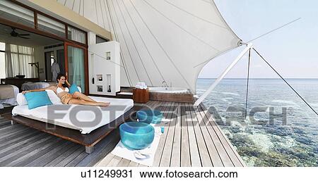 Young woman relaxing on deck by sea View Large Photo Image Stock Image - Young woman relaxing on deck by sea. Fotosearch