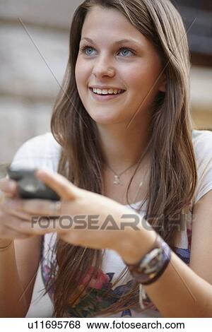 Stock Photo - Young woman using mobile phone. Fotosearch