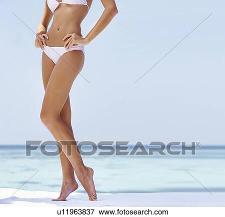 Young woman wearing bikini, low section View Large Photo Image Stock Photo - Young woman wearing bikini, low section. Fotosearch