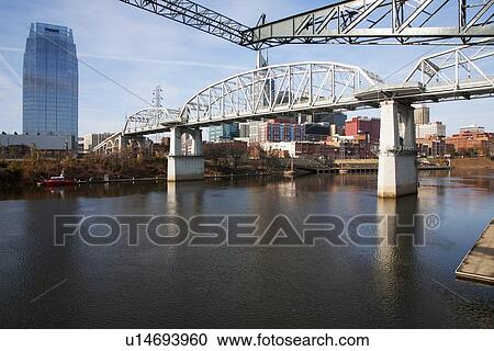 Stock Image - Cumberland River Pedestrian Bridge, Nashville Skyline, Tennessee. Fotosearch