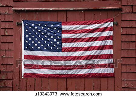 Stock Image - US Flag displayed on Red Barn, New England. Fotosearch