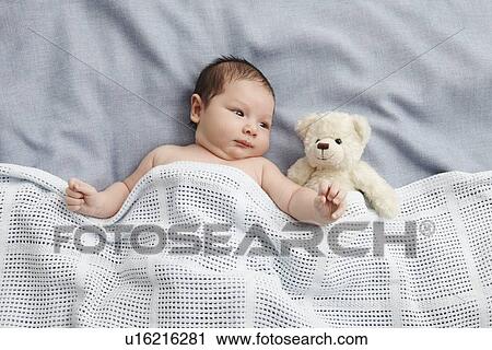 Baby boy and teddy bear laying in bed View Large Photo Image Stock Image - Baby boy and teddy bear laying in bed. Fotosearch