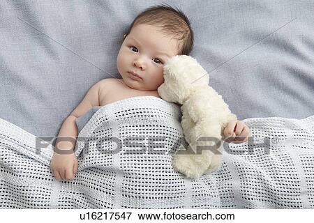 Baby boy and teddy bear laying in bed View Large Photo Image Stock Photo - Baby boy and teddy bear laying in bed. Fotosearch