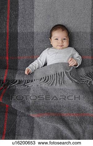 Stock Image - Baby boy laying in bed. Fotosearch