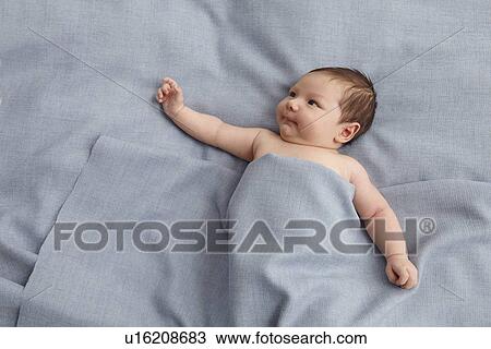 Stock Image - Baby boy laying in bed. Fotosearch