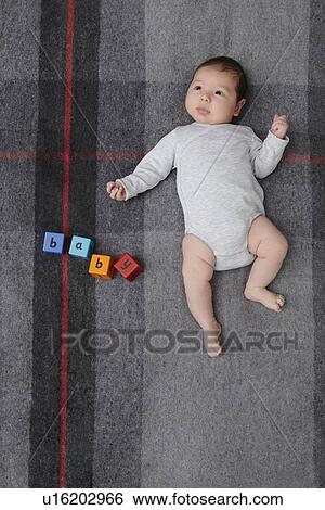 Baby boy laying on bed View Large Photo Image Stock Photograph - Baby boy laying on bed. Fotosearch