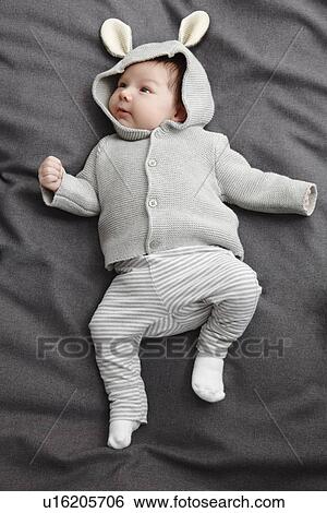 Stock Photograph - Baby boy laying on bed. Fotosearch