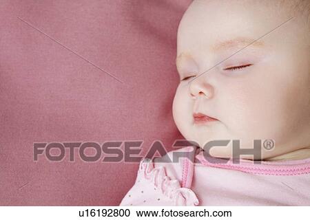 Stock Image - Baby girl sleeping in bed. Fotosearch