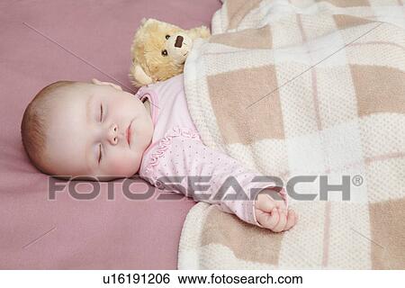 Stock Photograph - Baby girl sleeping in bed. Fotosearch