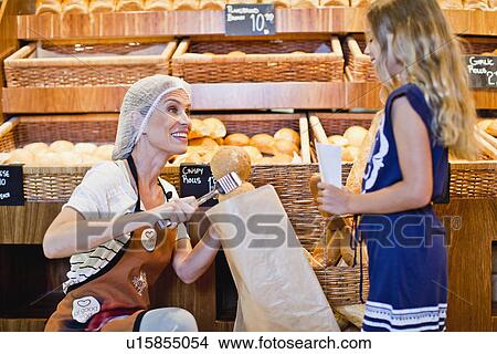 Baker helping girl in store View Large Photo Image Picture - Baker helping girl in store. Fotosearch