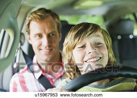 Boy driving car on fathers lap View Large Photo Image Stock Image - Boy driving car on fathers lap. Fotosearch