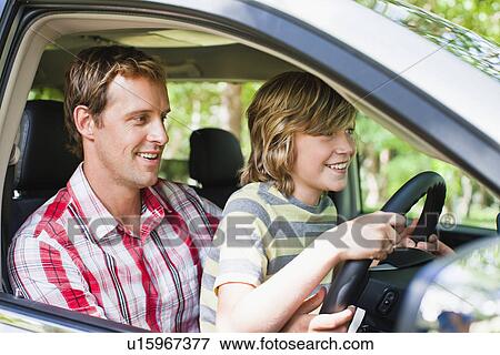 Stock Photo - Boy driving car on fathers lap. Fotosearch