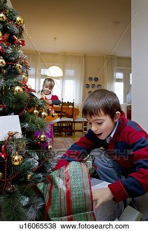 Boy examining Christmas presents View Large Photo Image Stock Photo - Boy examining Christmas presents. Fotosearch