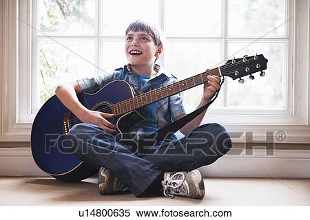 Boy playing guitar on floor View Large Photo Image Stock Photography - Boy playing guitar on floor. Fotosearch