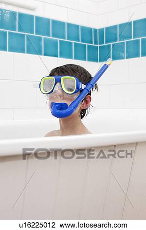 Stock Image - Boy wearing snorkel mask in bath. Fotosearch