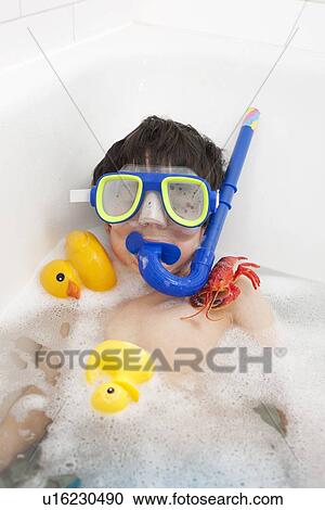 Stock Image - Boy wearing snorkel mask in bath. Fotosearch