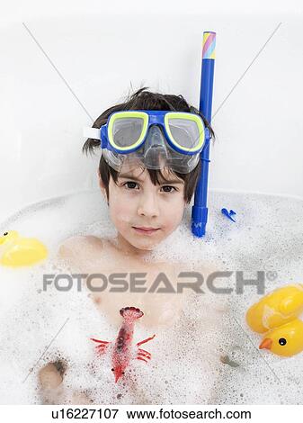 Stock Photo - Boy wearing snorkel mask in bath. Fotosearch