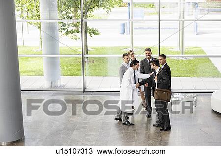 Stock Image - Business people and doctors greeting. Fotosearch