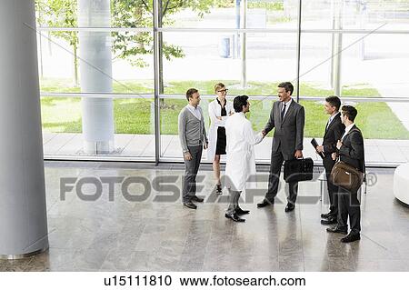 Stock Image - Business people and doctors greeting. Fotosearch