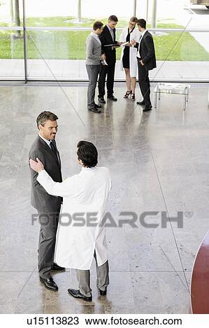 Stock Image - Business people and doctors greeting. Fotosearch