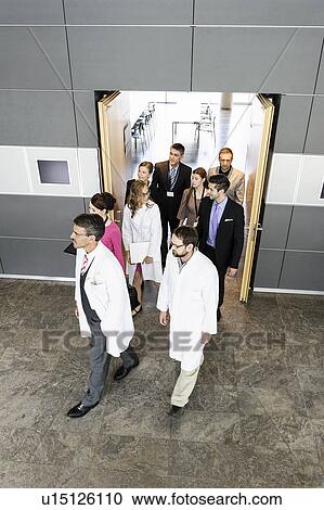 Stock Image - Business people and doctors in doorway. Fotosearch