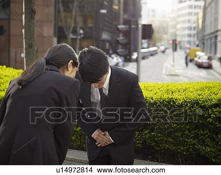 Business people bowing to each other View Large Photo Image Picture - Business people bowing to each other. Fotosearch