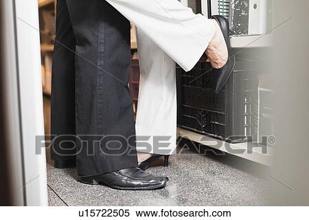 Stock Photography - Business people kissing in closet. Fotosearch