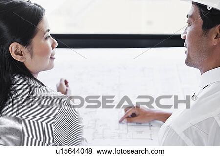 Stock Photo - Business people reading blueprints. Fotosearch