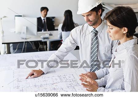 Stock Photograph - Business people reading blueprints. Fotosearch