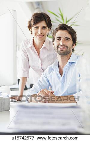 Business people smiling at desk View Large Photo Image Stock Photo - Business people smiling at desk. Fotosearch
