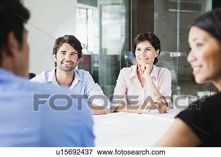 Stock Photo - Business people smiling in meeting. Fotosearch
