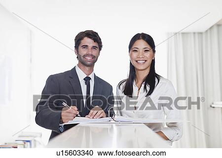 Stock Image - Business people smiling together. Fotosearch