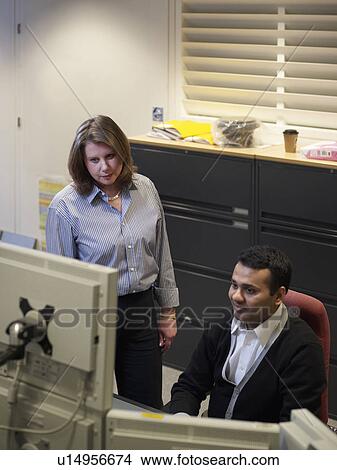 Picture - Business people talking at desk. Fotosearch