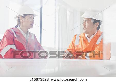 Stock Image - Business people talking at desk. Fotosearch