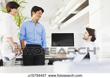 Business people talking at desk View Large Photo Image Stock Photo - Business people talking at desk. Fotosearch